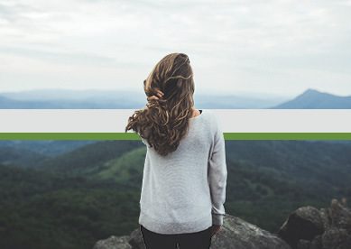 Woman stares out at a beautiful mountain scene